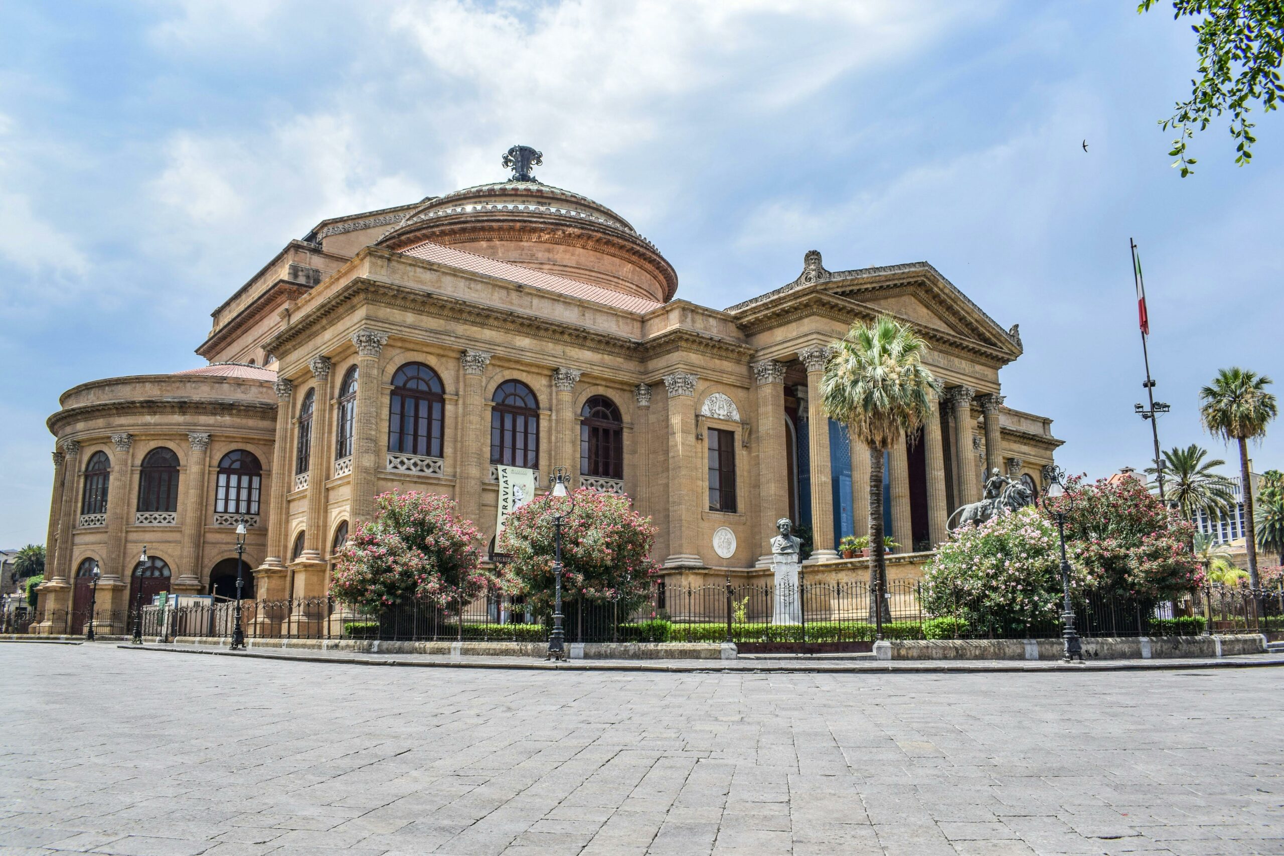 Low angle exterior of aged classic stone building of Teatro Massimo with columns and ornamental elements located square in Palermo