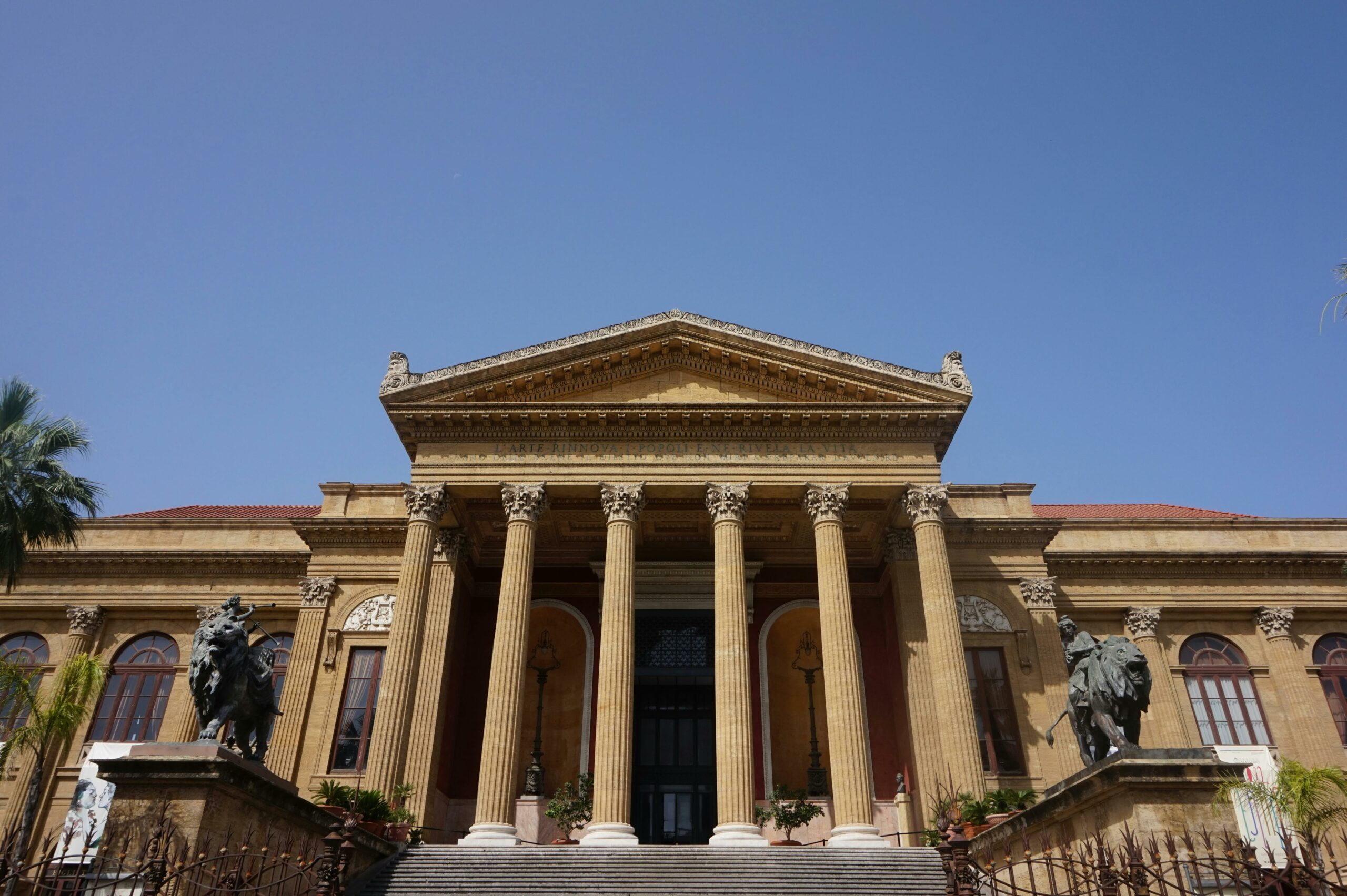 Stunning view of Teatro Massimo in Palermo showcasing neoclassical architecture under a clear blue sky.